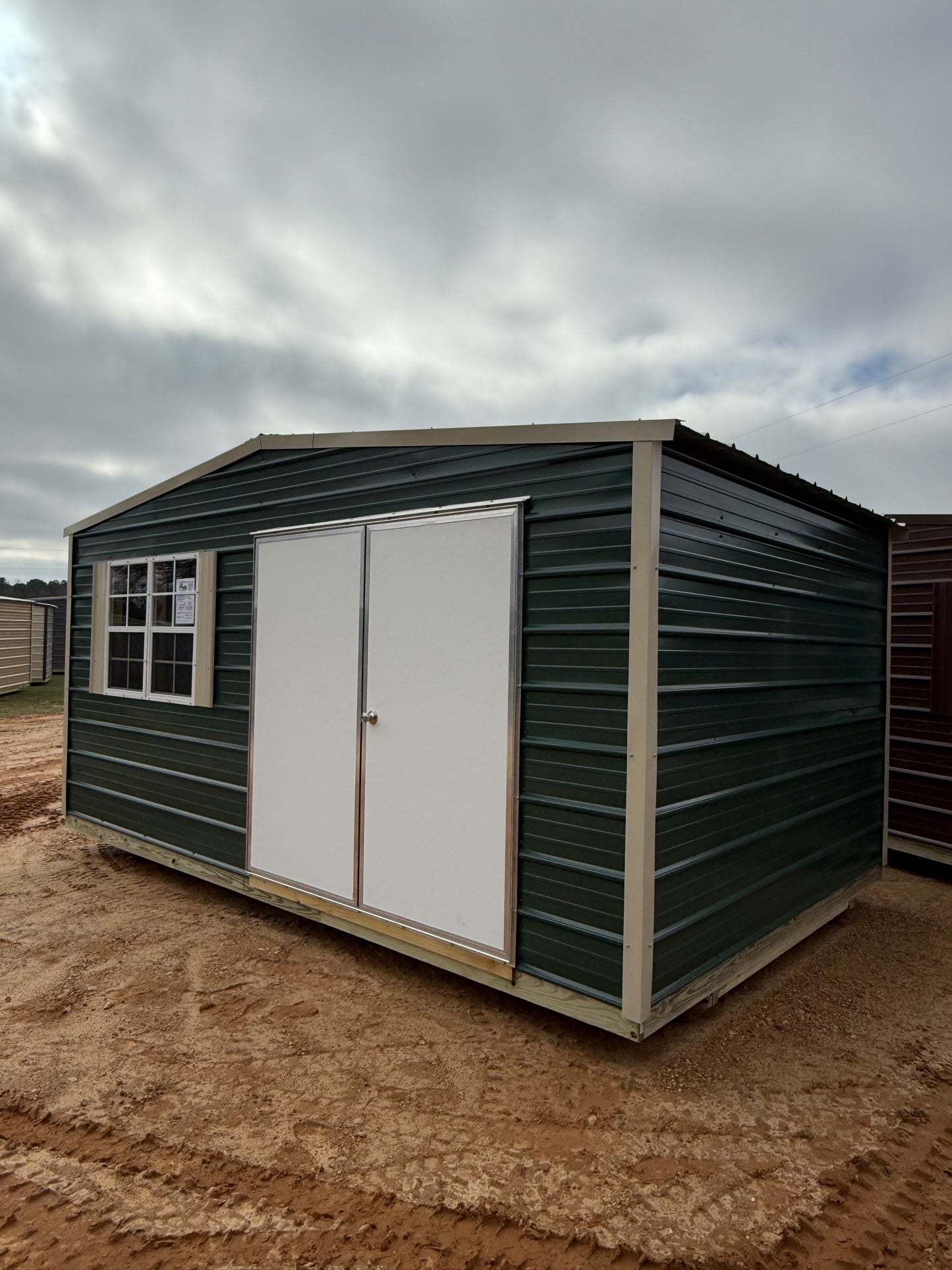 front and side view of 10x16 hunter green/light stone regular roof portable building