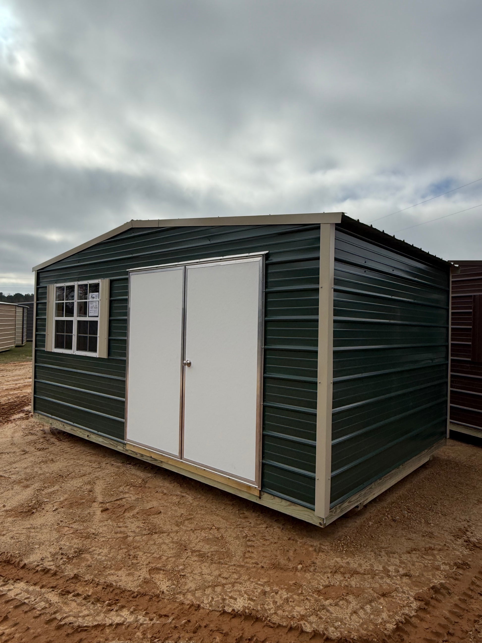front and side view of 10x16 hunter green/light stone regular roof portable building