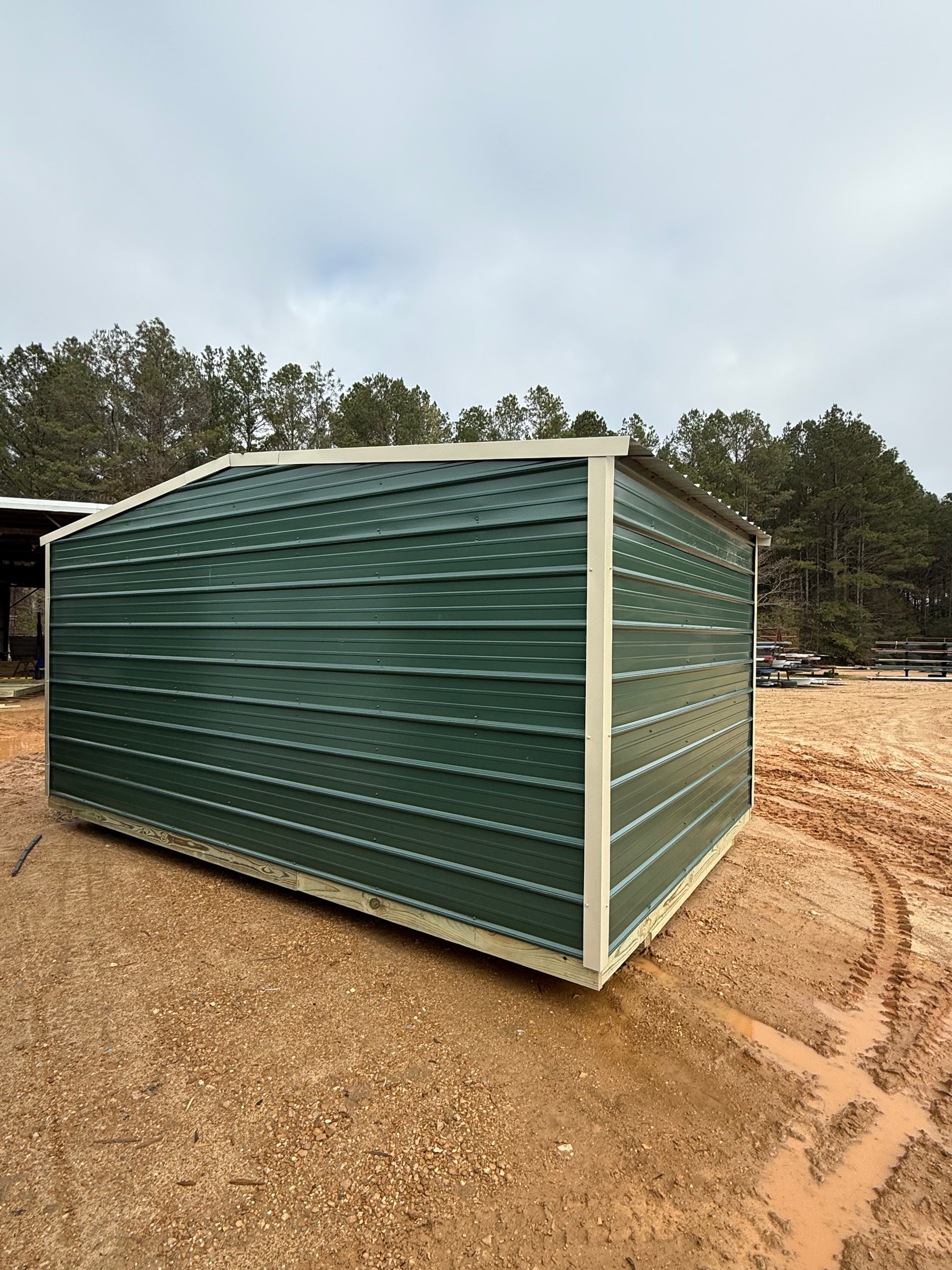 back/side view of 10x16 hunter green/light stone regular roof portable building 